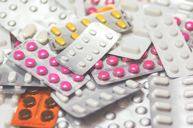 A pile of different colour pills within silver blister packs